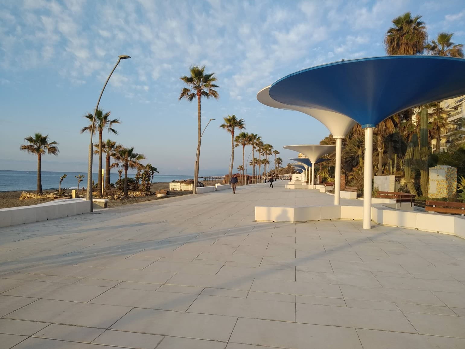 Paseo Marítimo de Estepona con sus pérgolas azules, las palmeras y la playa al fondo