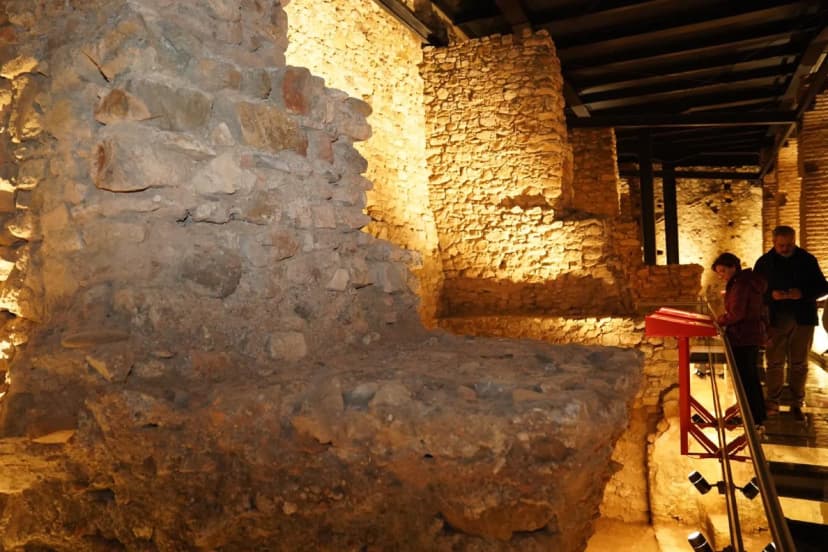 Restos de los muros interiores del Castillo de San Luis iluminados en el espacio expositivo